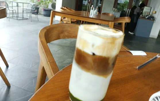 Gelas berisi sajian minuman berwarna-warni dengan gradasi cantik yang disajikan di atas meja kafe modern di Kota Bandung.