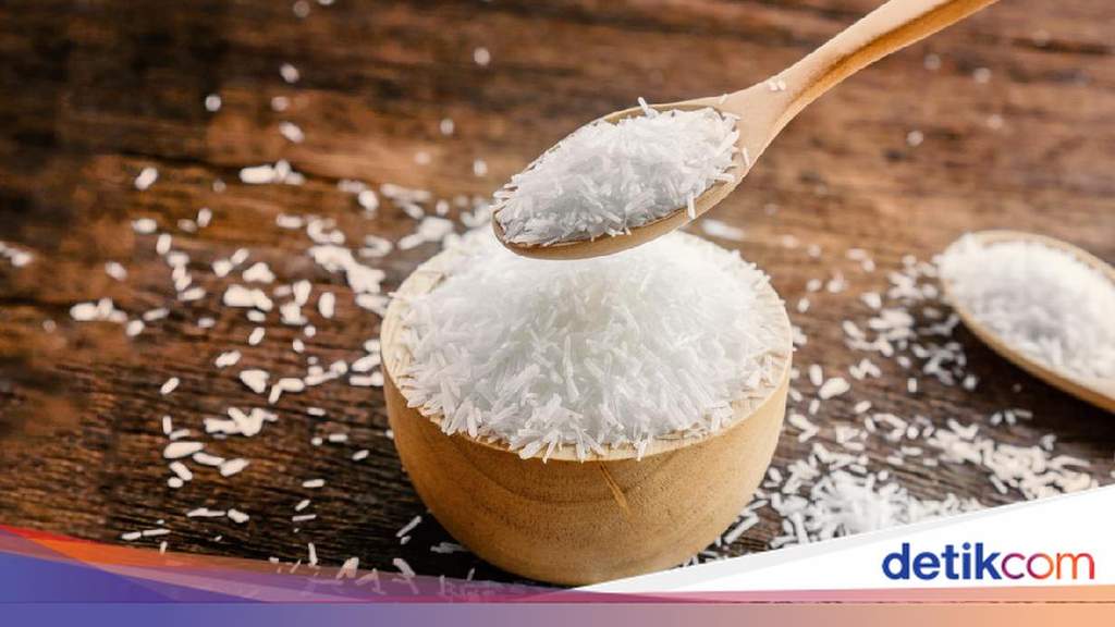 Ilustrasi bubuk putih monosodium glutamat atau micin di atas sendok takar putih dengan latar belakang dapur modern yang bersih.