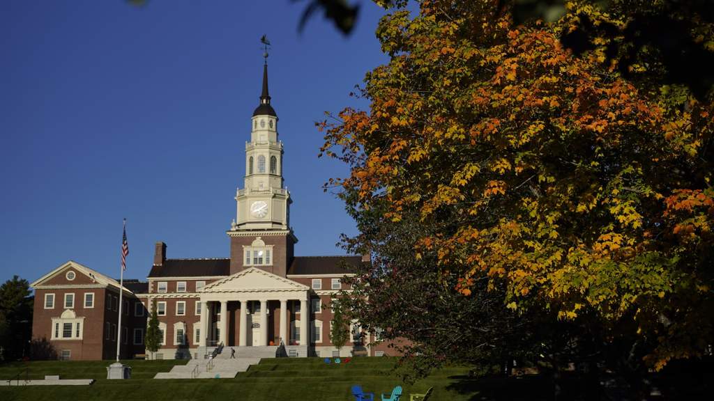Gedung perkuliahan universitas di Amerika Serikat dengan latar belakang mahasiswa yang berjalan di area kampus.