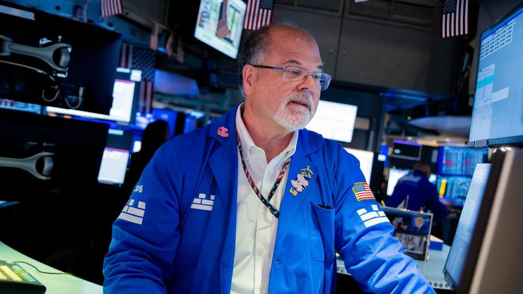 Grafik pergerakan indeks saham di bursa Wall Street dengan latar belakang layar perdagangan elektronik di New York Stock Exchange.