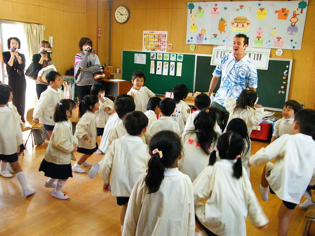 Suasana ceria anak-anak usia dini sedang belajar dan bermain bersama di dalam ruang kelas Taman Kanak-Kanak.