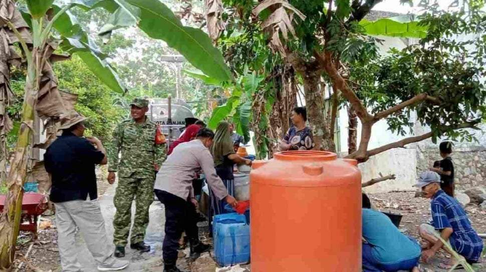 Petugas Badan Penanggulangan Bencana Daerah (BPBD) Kota Banjar sedang menyalurkan bantuan air bersih menggunakan truk tangki kepada warga di Dusun Pangasinan.